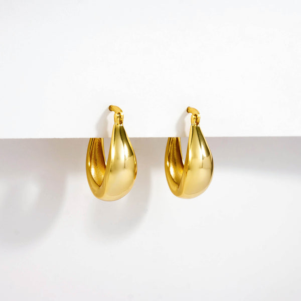 18k gold plated 925 Sterling Silver ‘Bold Oval Hoops’ Earrings with Latch closure hanging on white background