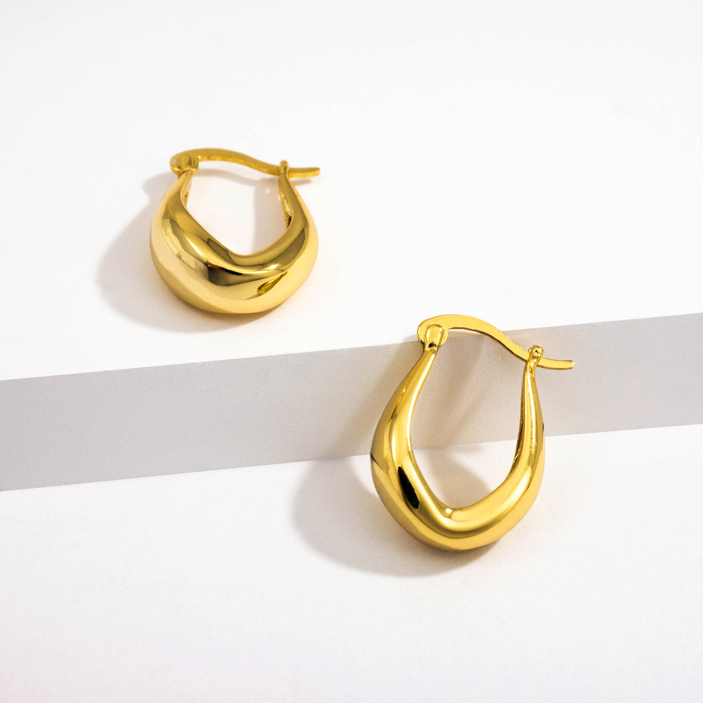 18k gold plated 925 Sterling Silver ‘Bold Oval Hoops’ Earrings with Latch closure laying on white background