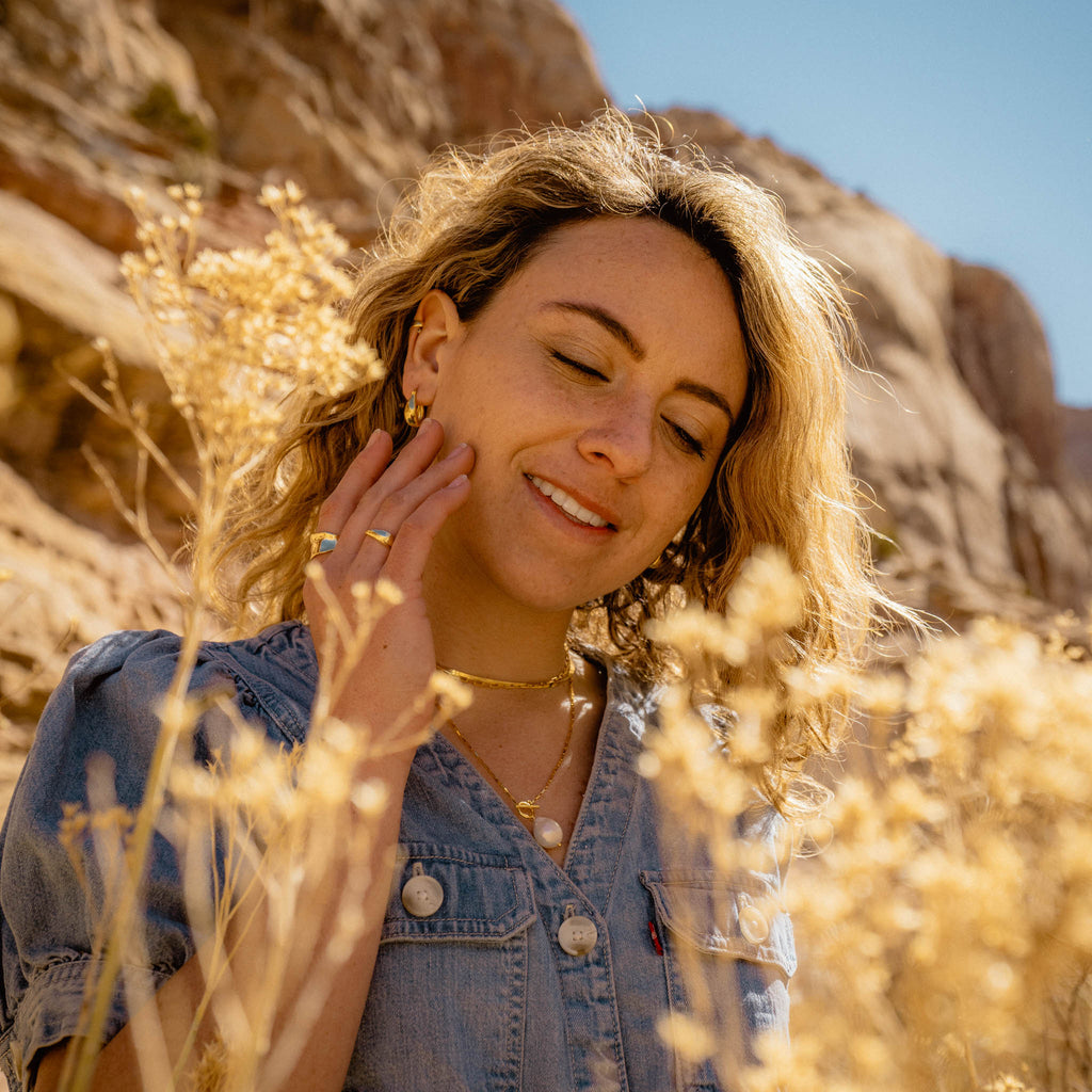 Woman in the desert with flowers modeling 18k gold plated 925 Sterling Silver ‘Bold Oval Hoops’ Earrings